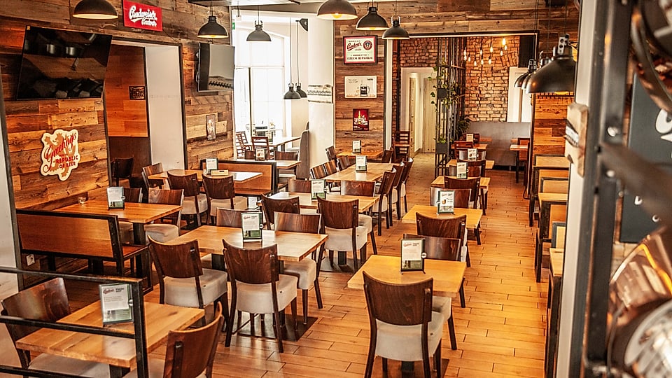 Inside Dřevný Kocúr Poznań – wooden tables and industrial lamps