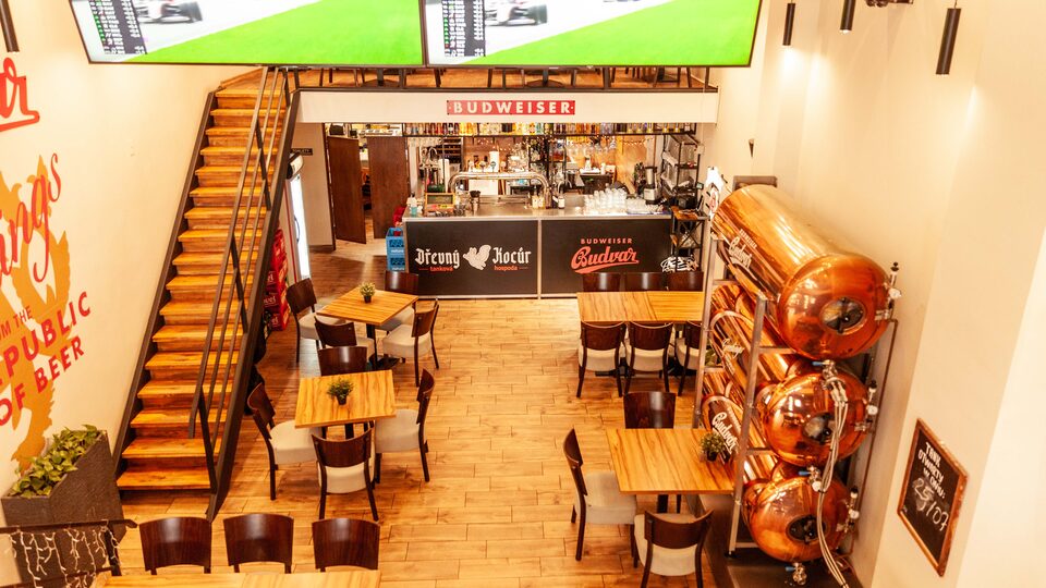 Wnętrze restauracji Dřevný Kocúr przy Rynku we Wrocławiu – jasna sala z antresolą